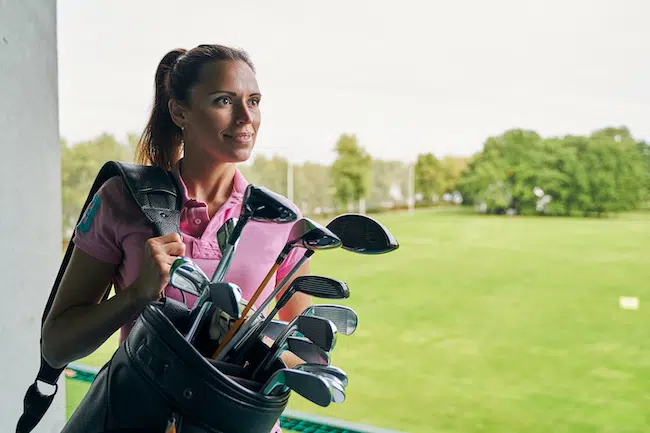Contented-female-athlete-holding-a-golf-bag-2021-09-03-14-36-11-utc