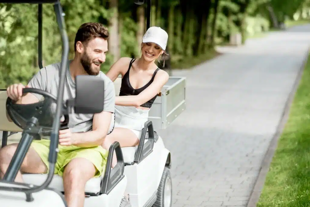 Couple in the golf cart laughing on a path