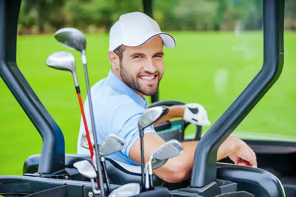 calcutta in golf. Man in golf cart smiling