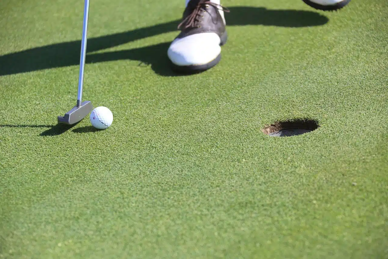 golfer putting a few feet from hole