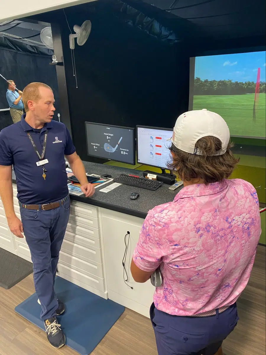 Charles Moore, master fitter, works with golf student at launch monitor during PGA TOUR Superstore full bag club fitting